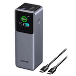 The UGREEN 25000mAh 200W Fast Charging Power Bank 35525B in gray features a digital display at 100% charge, multiple USB ports, and comes with two USB-C cables—perfect for rapid charging. Buy in Kuwait.